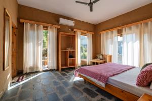 een slaapkamer met een bed en grote ramen bij The Winter Courtyard by AVVAs Stays in Bir