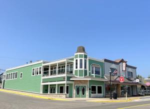 a green building on the corner of a street at Pier Harbor #1 in Saint Ignace
