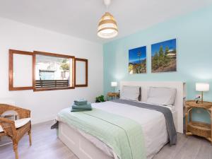 a bedroom with a large bed and a chair at Live Guimar los Piramides in Chabaica +33 photos