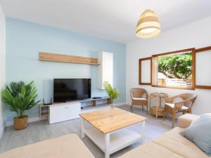 a living room with a couch and a tv and a table at Live Guimar los Piramides in Chabaica
