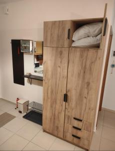 a large wooden cabinet in a kitchen with a bed at SiviriLovelyApartment in Siviri