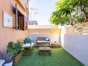 an outdoor patio with chairs and a table at Live Guimar los Piramides in Chabaica
