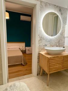 a bathroom with a sink and a mirror and a bed at Moonlight Drive in Cava deʼ Tirreni