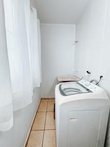 a washer and dryer in a room with a window at Apto Térreo Ótima localização Com AC in Três Lagoas