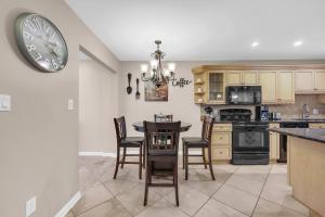 a kitchen with a table and a clock on the wall at Driftwood Days Pet Friendly Beach Home in Myrtle Beach