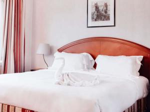 布加勒斯特普尔曼布加勒斯特世界贸易中心酒店的白色的床、白色床单和枕头