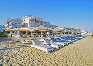 a row of lounge chairs and umbrellas on a beach at Sea & Luxury in Perea