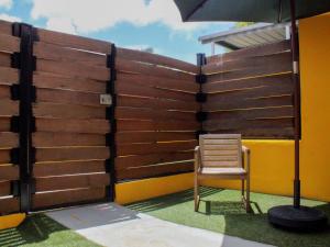 a chair sitting next to a fence with an umbrella at Villas at Auxilio Mutuo 102 in San Juan