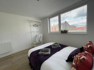 a bedroom with a bed with two towels on it at Modern Apartment overlooking Andover High Street in Andover +9 photos