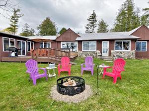a group of chairs sitting around a fire pit at Lakeside Lodge in Saint Ignace