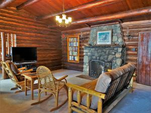 a living room with a stone fireplace and a tv at Lakeside Lodge in Saint Ignace