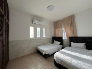 a bedroom with two beds and a window at شالية فندقي في شاطي البرادايس للعائلات in Durat  Alarous
