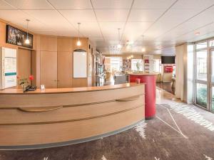 a restaurant with a counter in the middle of a room at ibis Saint Brieuc Yffiniac in Yffiniac
