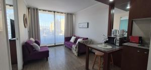 a living room with purple chairs and a table at Departamento Salar in Calama