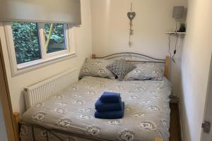 a small bed with a blue towel on it at 2-Bed Cabin Sleeps 4 -Small Pets Ok -Free Parking in Denbigh