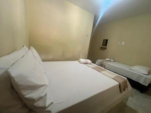 a bedroom with a large white bed in a room at Pousada Alto do Tambá in São Francisco