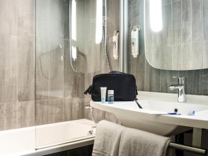 Un baño con lavabo, inodoro y bañera. en Hotel ibis Braga, en Braga