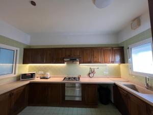 a kitchen with wooden cabinets and a stove top oven at شالية فندقي في شاطي البرادايس للعائلات in Durat  Alarous +11 photos