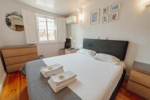 a bedroom with a white bed with towels on it at Dear Porto By Hosty in Porto