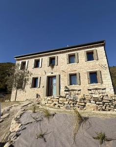 - un bâtiment en pierre avec des fenêtres et un mur en pierre dans l'établissement Ai Sassi Valdobbiadene, à Valdobbiadene