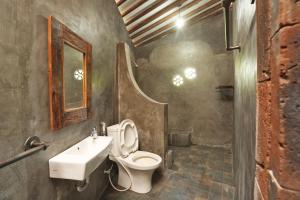 a bathroom with a toilet and a sink at Omahe Kancaku in Balong