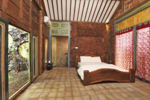 a bedroom with a bed in a brick wall at Omahe Kancaku in Balong