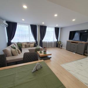 a living room with a couch and a flat screen tv at Balkan Tower Deluxe Ultra in Gabrovo