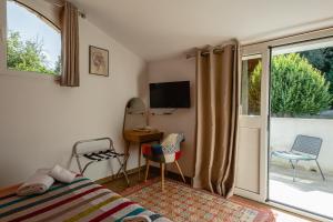 a bedroom with a bed and a sliding glass door at Auberge U n'Antru Versu in San-Gavino-di-Carbini