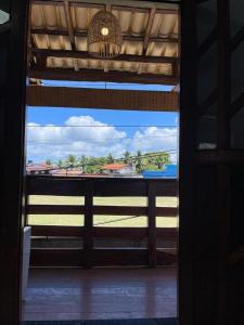 an open door to a room with a view of the ocean at Pousada vila jesuíta in Ilha de Boipeba