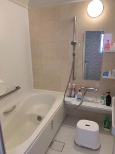 a bathroom with a white tub and a toilet at Formosa Hakodate - Vacation STAY 17455 in Hokuto