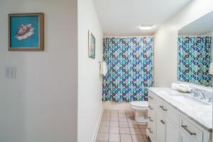 a bathroom with a sink and a toilet at Sandpiper #108 in Tybee Island +18 photos