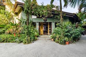 Un edificio con plantas delante. en VIP La Lora Beach Villa best family home, en Santa Teresa Beach