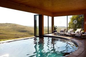 a swimming pool in a house with windows at Brahman Hills - Gardens, Spa, Hotel & Villas in Nottingham Road