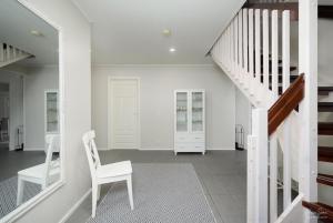 Cette chambre blanche dispose d'une chaise et d'escaliers blancs. dans l'établissement Villa Metsola, à Kalajoki