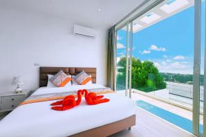 two red stuffed animals sitting on a bed in a bedroom at Bobut beach, Koh Samui, Thailand, sea view, four-bedroom, four-bathroom villa C in Amphoe Koh Samui