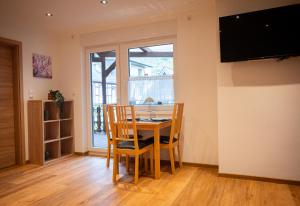 Un comedor con mesa y sillas y un televisor. en Appartements Jupp und Hilde, en Ernst
