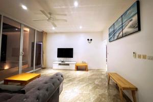 a living room with a couch and a flat screen tv at Bobut beach, Koh Samui, Thailand, sea view, four-bedroom, four-bathroom villa C in Amphoe Koh Samui
