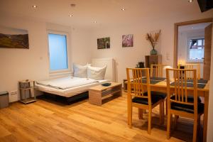 Sala de estar con cama y mesa de comedor en Appartements Jupp und Hilde, en Ernst