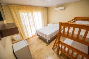 a bedroom with two bunk beds and a window at Pousada San José in Pântano Grande