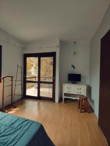 a bedroom with a bed and a desk and a window at A casa da Floresta in Florianópolis