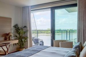 a bedroom with a bed and a balcony at Fulham Pier Hotel in London