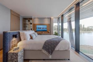 a bedroom with a large bed and large windows at Fulham Pier Hotel in London