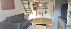 a living room with a couch and a wooden table at Cœur de Provence in Marignane