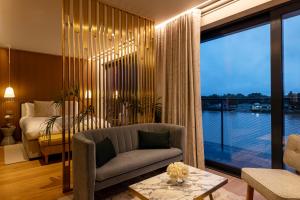 Una sala de estar con un sofá y un dormitorio. en Fulham Pier Hotel, en Londres