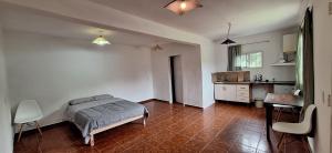 a bedroom with a bed and a kitchen with a table at Apart Sierras Chicas in Río Ceballos +4 photos