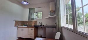 a kitchen with a sink and a large window at Apart Sierras Chicas in Río Ceballos