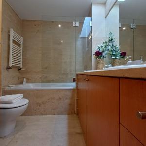 a bathroom with a tub and a toilet and a sink at Tasteful Beach Getaway with Private Terrace in Matosinhos +26 photos