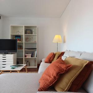 a living room with a couch and a tv at Tasteful Beach Getaway with Private Terrace in Matosinhos