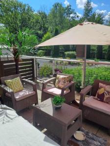 un patio avec des chaises, une table et un parasol dans l'établissement Solankowe Zacisze, à Inowrocław