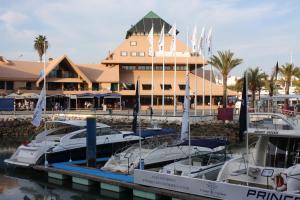 three boats docked in a marina in front of a building at Timeless Vacations Vilamoura Marina Flat WIFI & Pool in Vilamoura